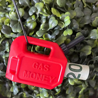 Gas Money Christmas Ornament is a red container labeled 'Gas Money' with a dollar bill inside, on a green leafy background