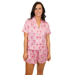 Tied with a Bow Satin Pajama Short Set is a button up pajama set that is light pink with bow designs